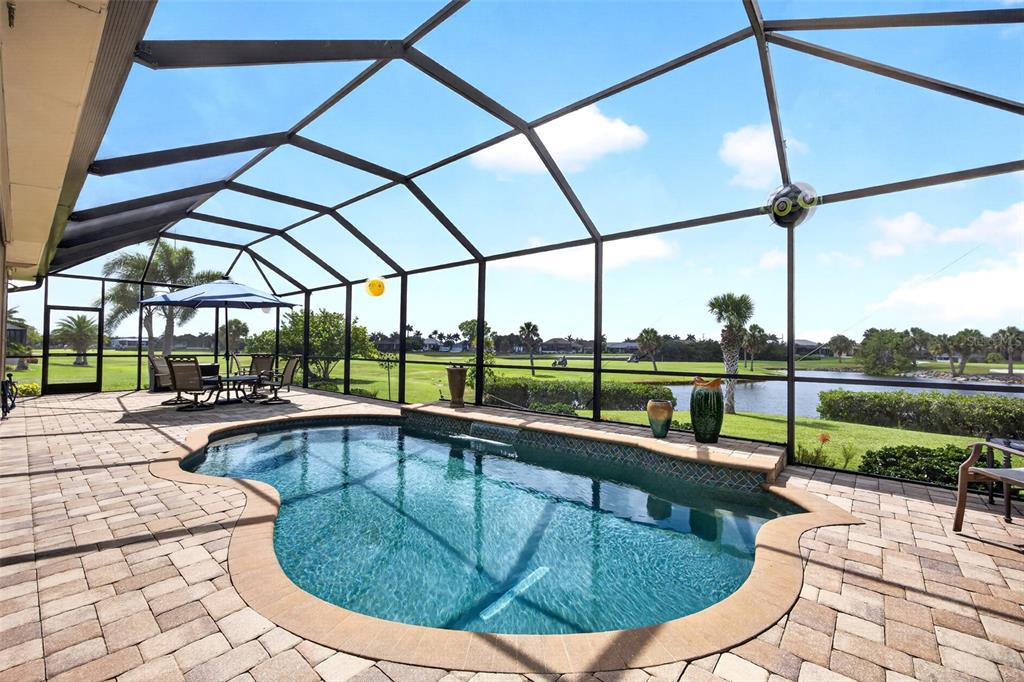 A screened-in pool patio overlooks a golf course and a small pond — 2107 PADRE ISLAND DRIVE, PUNTA GORDA, FL