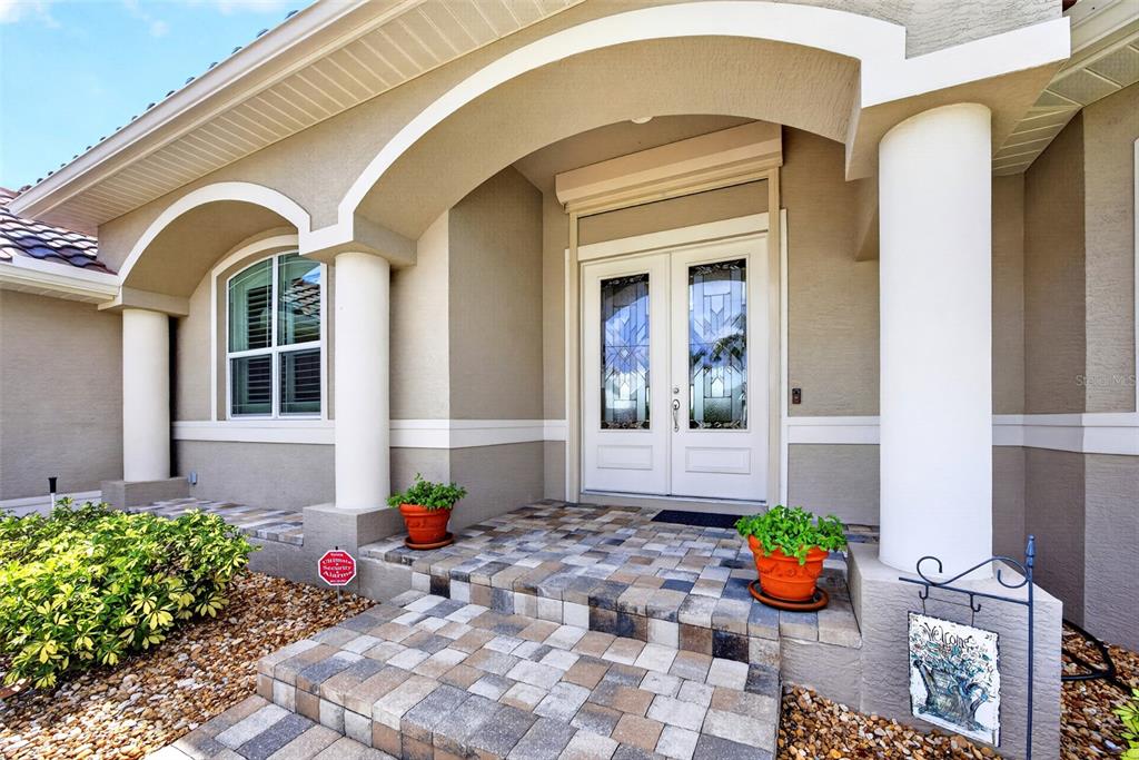 A front entrance with double glass doors, stone steps, and two white columns — 2107 PADRE ISLAND DRIVE, PUNTA GORDA, FL