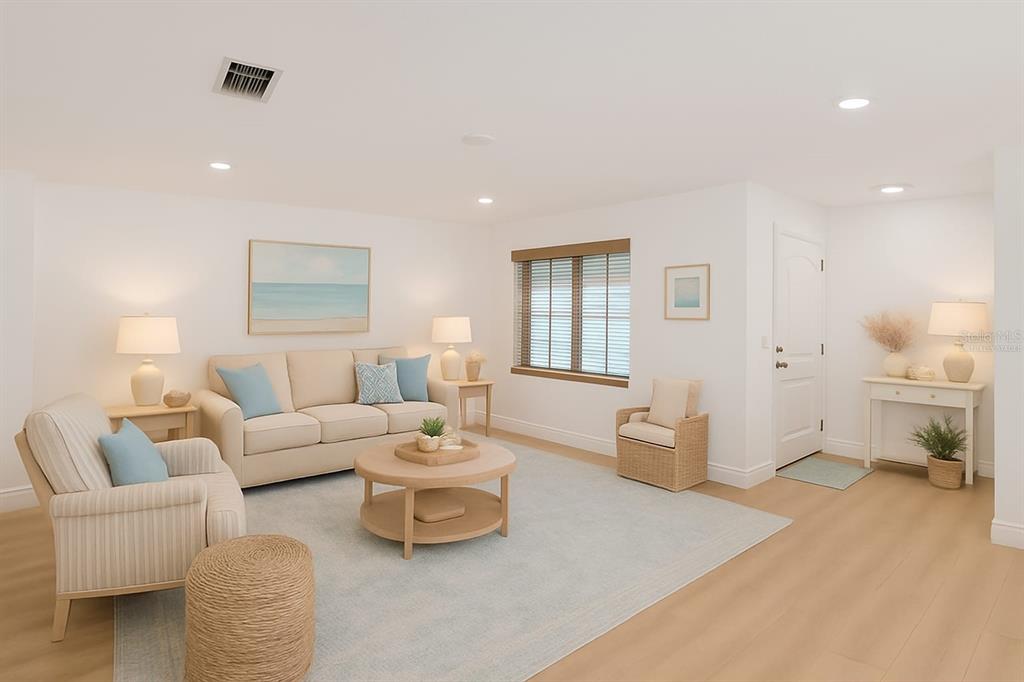 A bright living room features a beige sofa, armchairs, a coffee table, and light wood flooring — 325 GREEN MANOR DRIVE, SUN CITY CENTER, FL