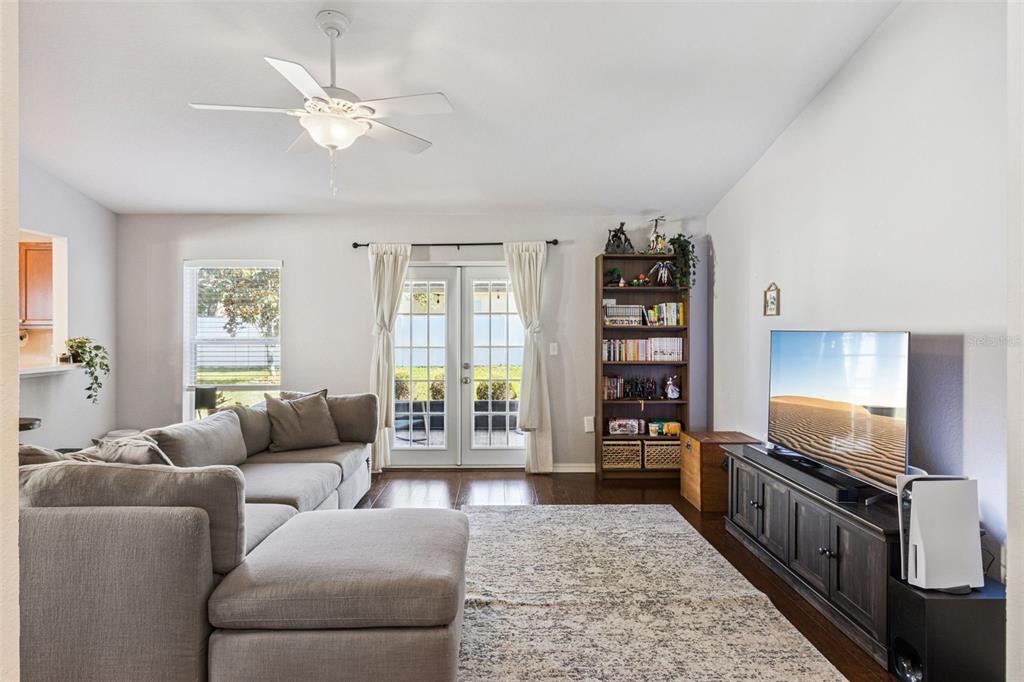 A living room features a grey sectional sofa, a television on a console, and bookshelves — 1920 COUNTRY MANOR STREET, BARTOW, FL