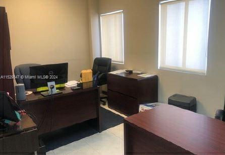 An office space features two wooden desks, a black office chair, and two windows — 3300 NW 112th Ave # 13, Doral FL 33172, DORAL, FL