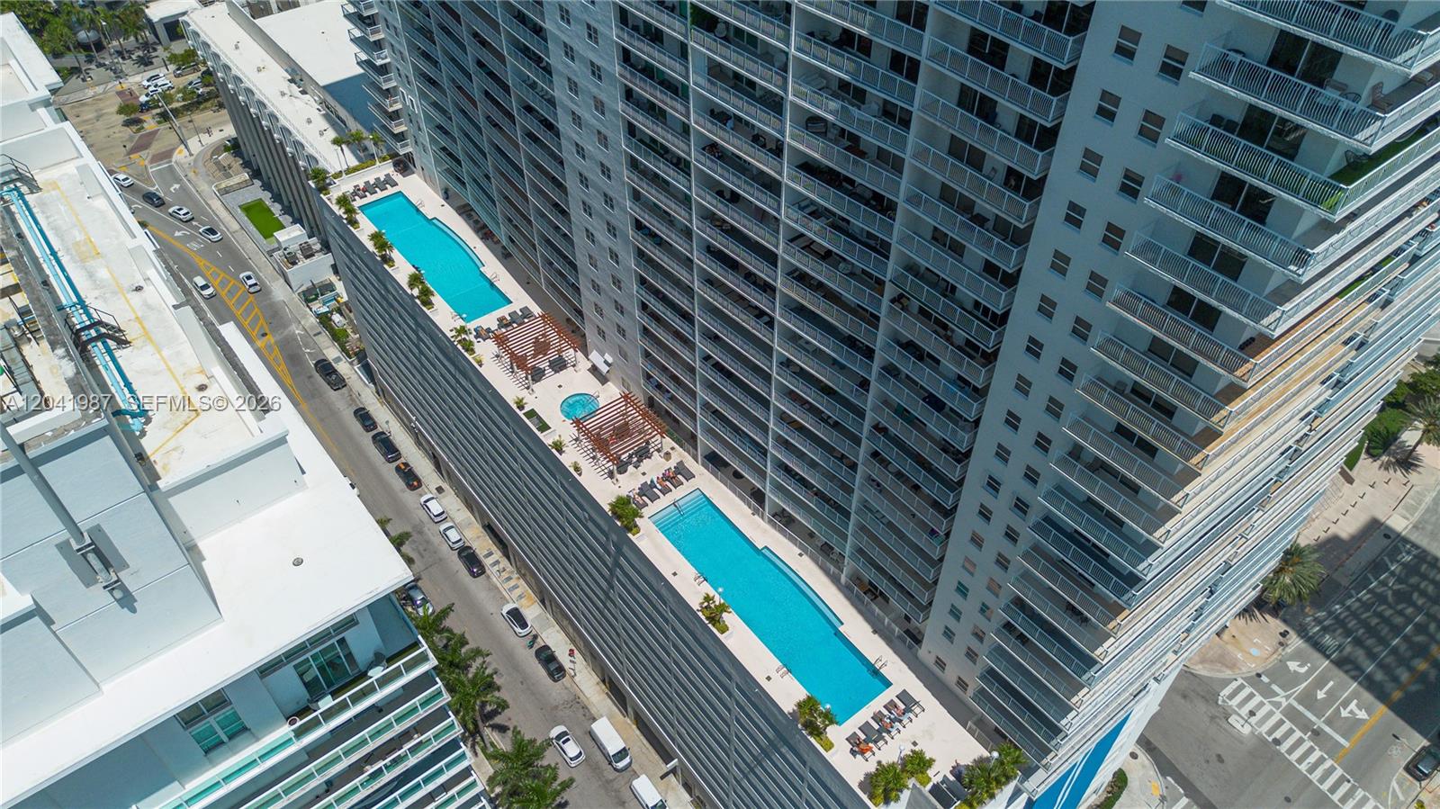 An aerial view shows a high-rise building with two swimming pools on a terrace — 1200 Brickell Bay Dr # 4121, Miami FL 33131, MIAMI, FL