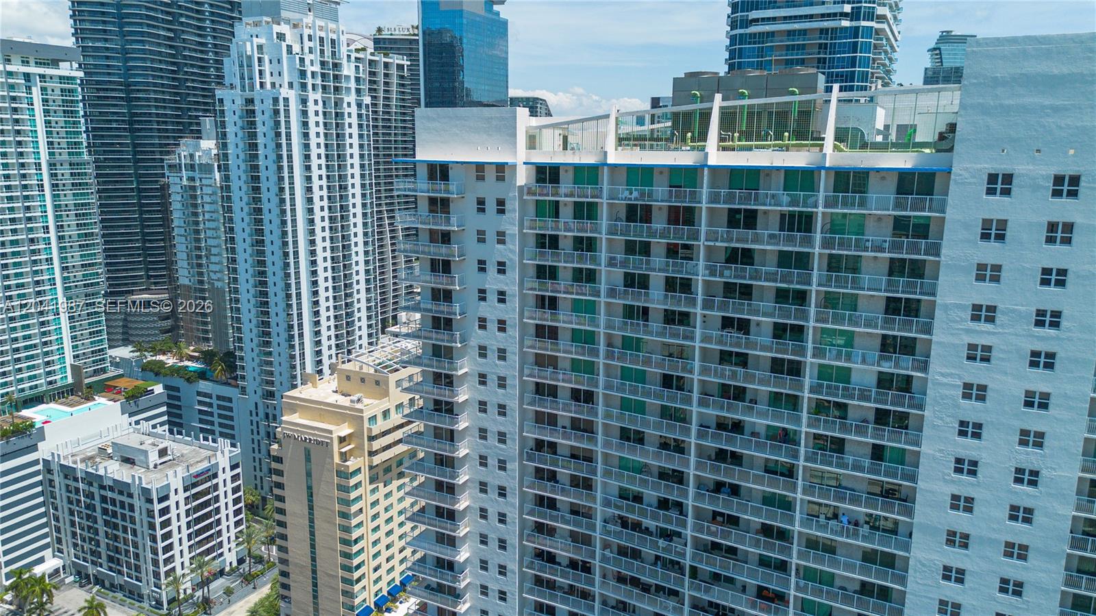 An aerial view shows a high-rise residential building with balconies alongside other urban skyscrapers — 1200 Brickell Bay Dr # 4121, Miami FL 33131, MIAMI, FL