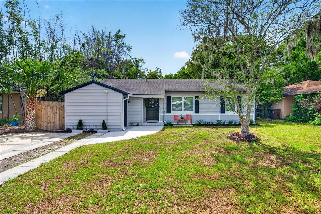 A single-story gray house with a front lawn, a concrete walkway, and a palm tree — 212 S GLENWOOD AVENUE, ORLANDO, FL