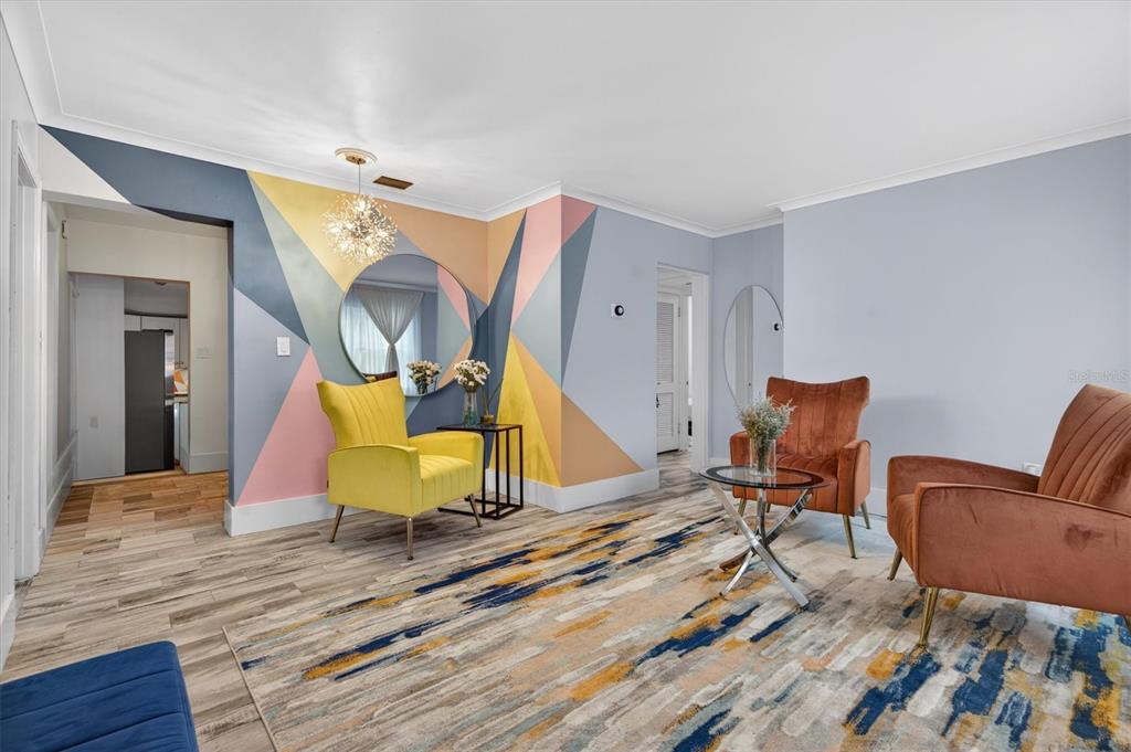 A living room features a geometric accent wall, colorful armchairs, and a patterned area rug — 212 S GLENWOOD AVENUE, ORLANDO, FL