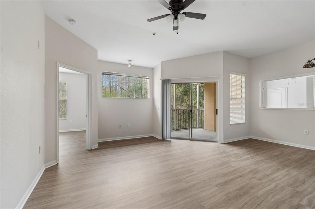 An entryway leads into a living area with wood-look flooring and a screened balcony — 5125 PALM SPRINGS BOULEVARD UNIT 4305, TAMPA, FL
