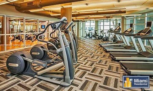 A gym room features several elliptical machines and treadmills on a patterned tile floor — 244 Biscayne Blvd # 3004, Miami FL 33132, MIAMI, FL