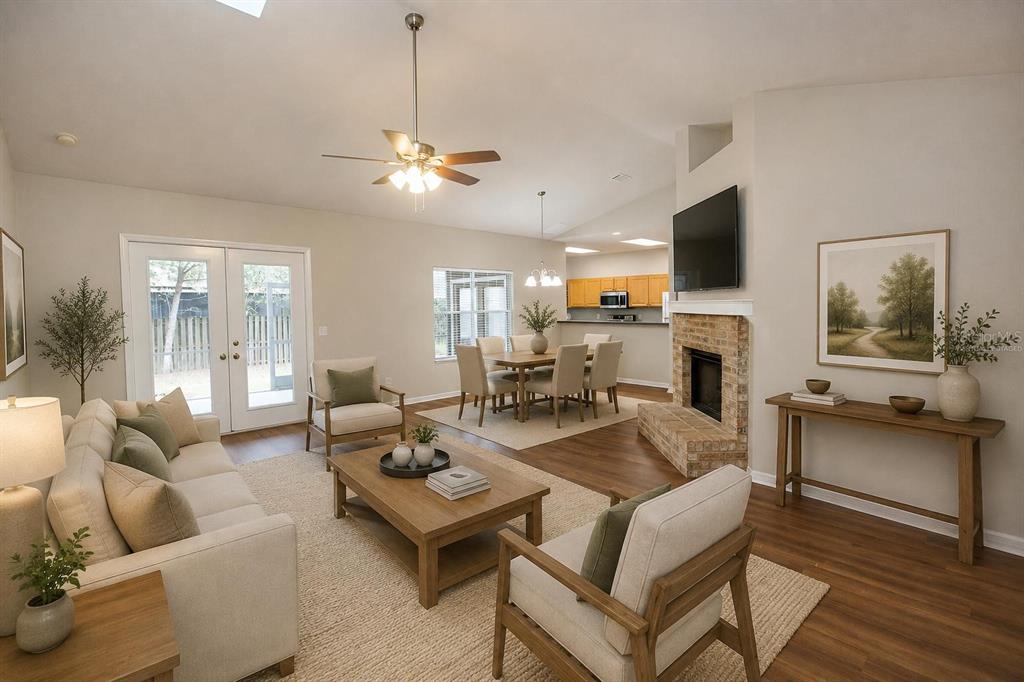 A living room with a brick fireplace, wood flooring, and an adjacent dining area — 4314 NW 35TH STREET, GAINESVILLE, FL