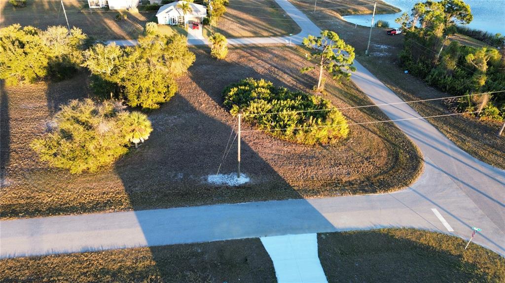 An aerial view shows a vacant, grassy corner lot with a utility pole and trees — 19 REEF COURT, PLACIDA, FL