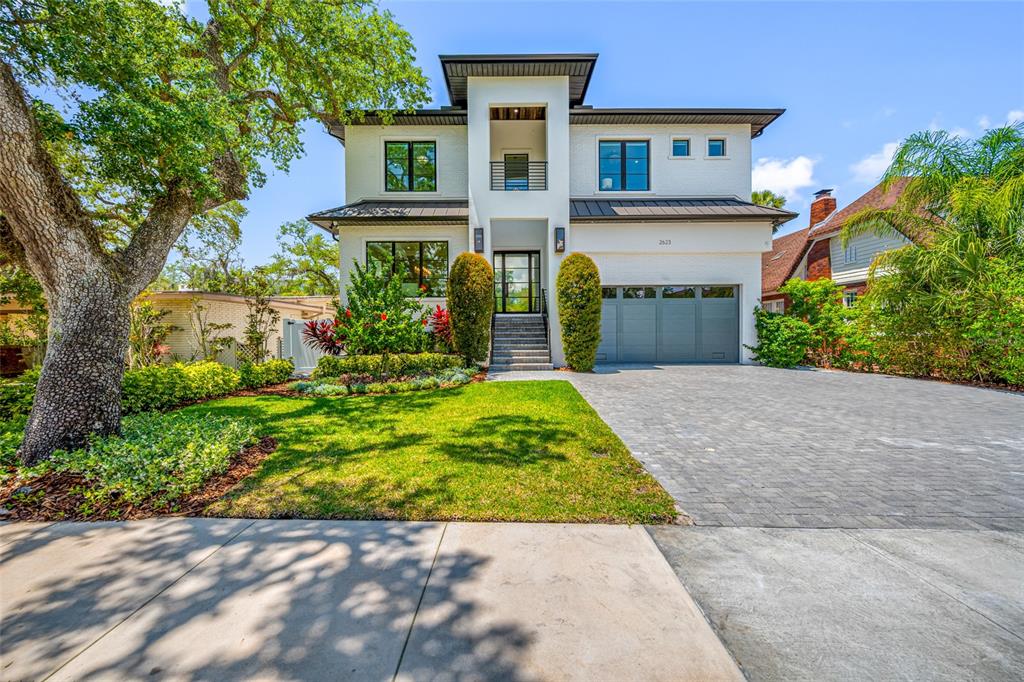A modern two-story white house features a gray garage, a paved driveway, and landscaping — 2623 S PARKVIEW STREET, TAMPA, FL