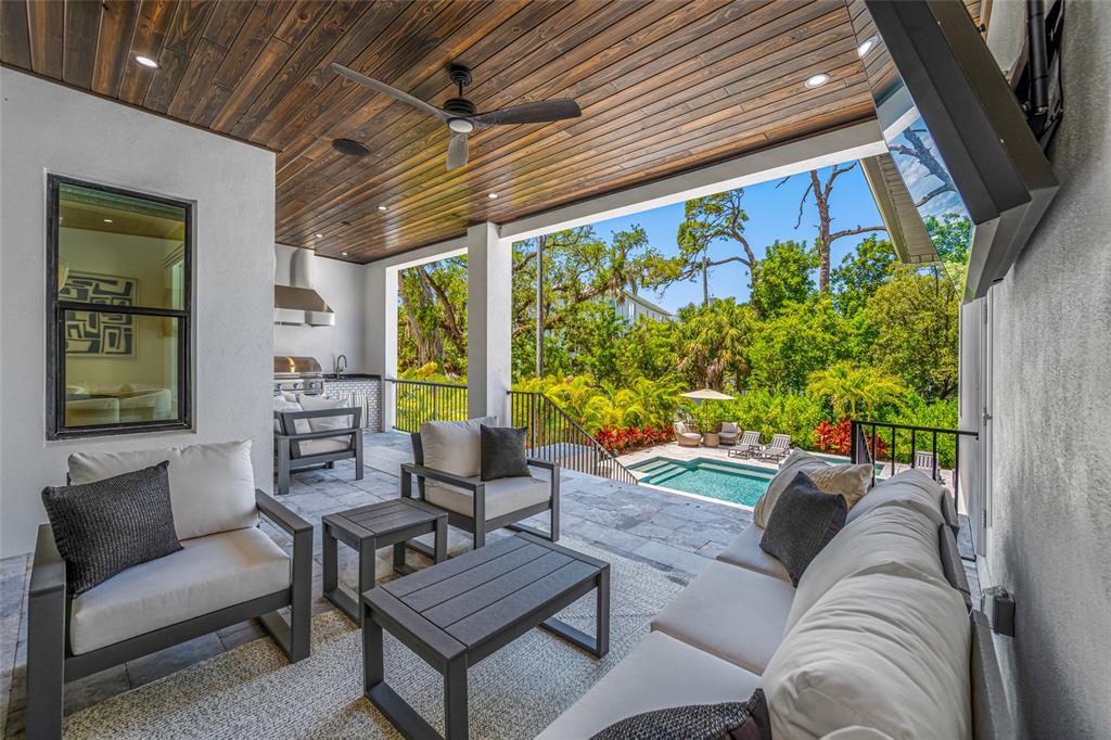 A covered outdoor patio features a seating area, an outdoor kitchen, and a swimming pool — 2623 S PARKVIEW STREET, TAMPA, FL