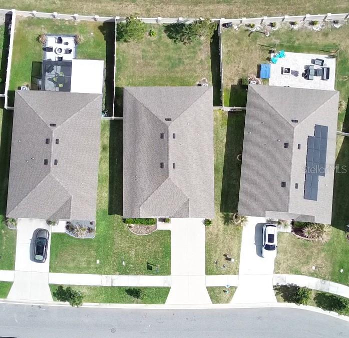 An aerial view shows three suburban houses with driveways, backyards, and a shared street — 7980 BROAD POINTE DRIVE, ZEPHYRHILLS, FL
