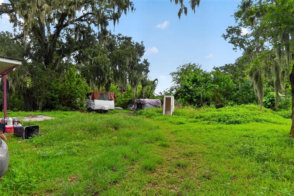 A grassy yard features a small camper, a covered structure, and a standalone door frame — 505 FULTON STREET, DAYTONA BEACH, FL