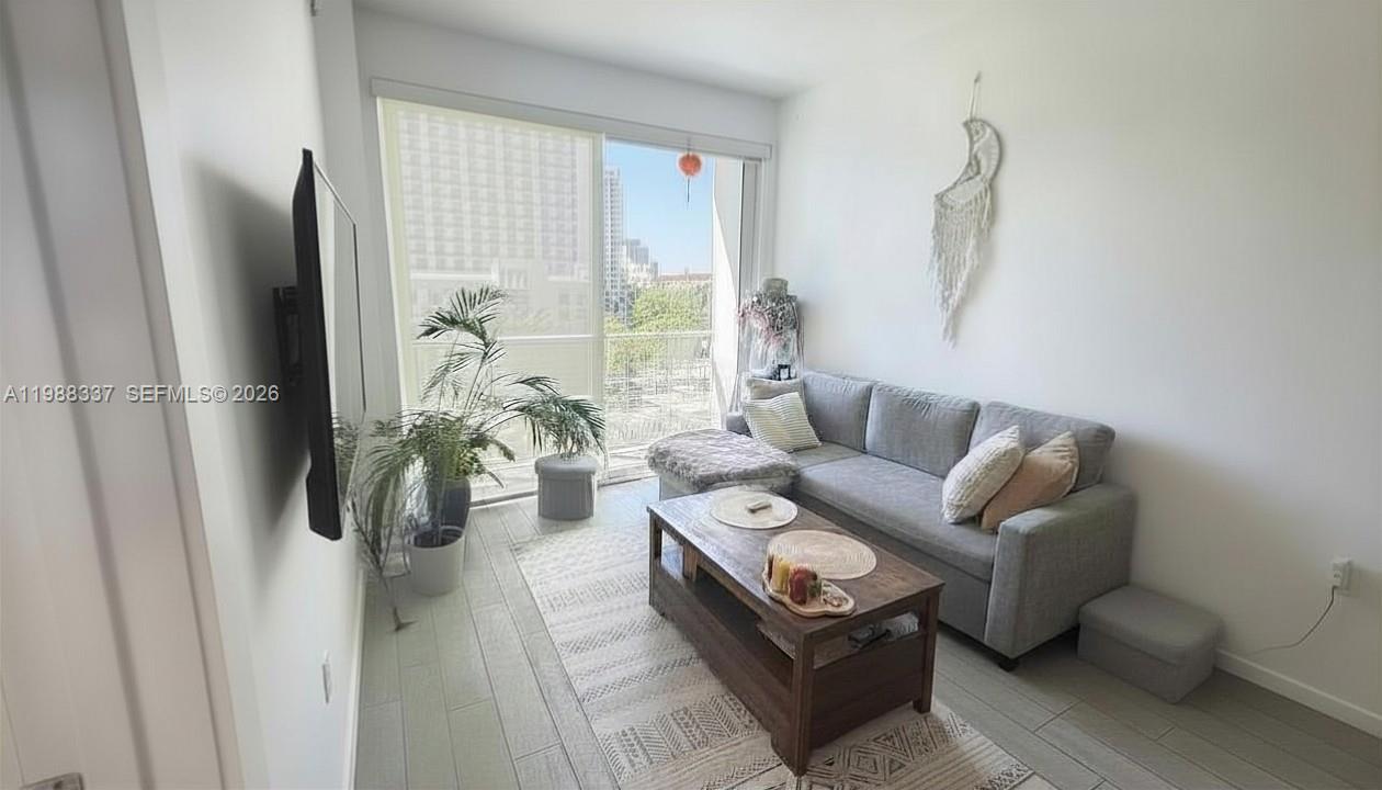 A living room features a gray sectional sofa, a coffee table, and a wall-mounted television — 321 NE 26th St # 514, Miami FL 33137, MIAMI, FL