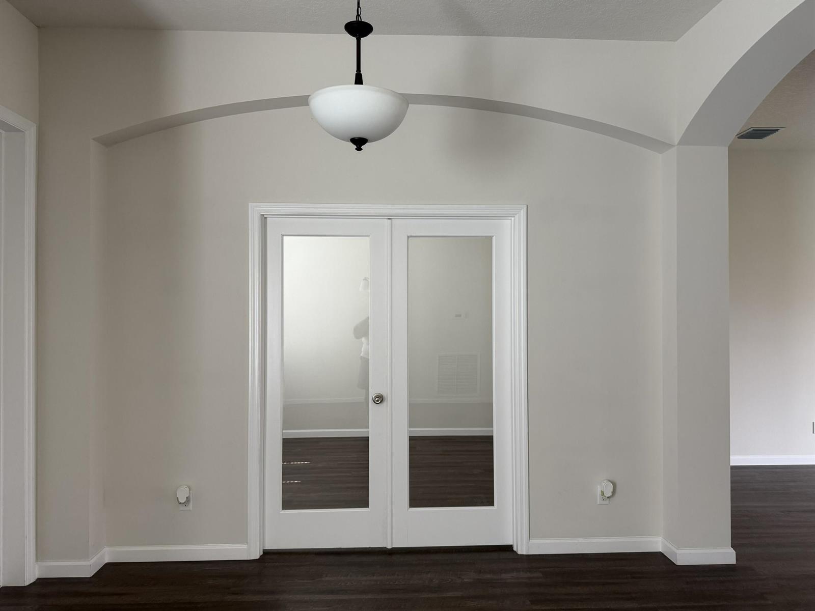 A room features white double French doors centered under an arched ceiling and pendant light — 4634 SW Athena Drive, FL 34953, FL