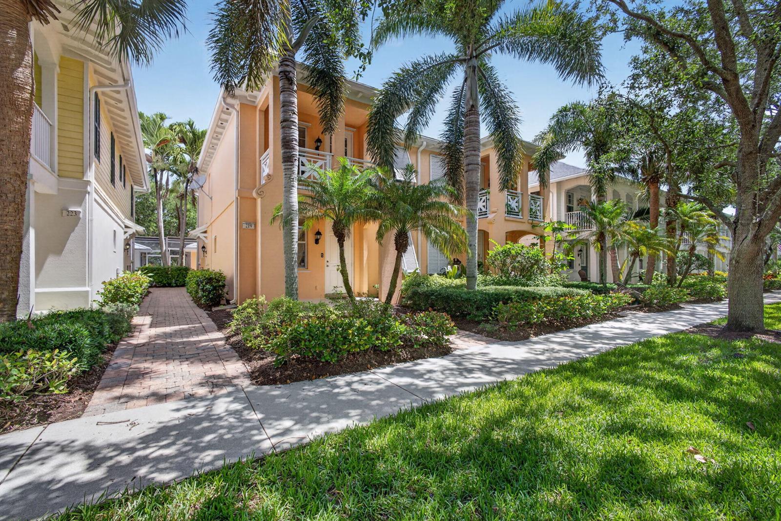 A multi-story peach-colored building with palm trees and a brick walkway in a sunny neighborhood — 219 Soriano Drive, Jupiter FL 33458, JUPITER, FL