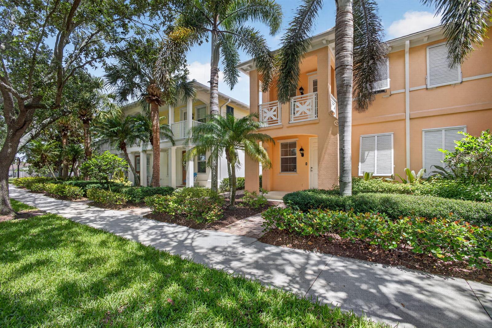 Two multi-story townhomes with balconies and palm trees stand along a sidewalk — 219 Soriano Drive, Jupiter FL 33458, JUPITER, FL