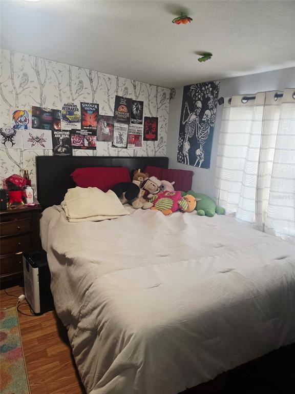 A bedroom features a bed with a white comforter, wall posters, and a skeleton tapestry — 8311 N 18TH STREET, TAMPA, FL