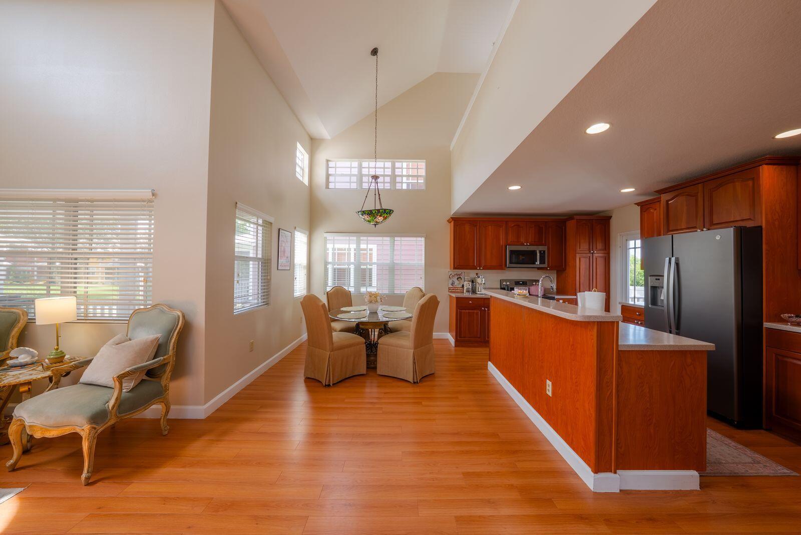 A dining area and kitchen feature hardwood floors, vaulted ceilings, and wooden cabinetry — 4334 Us-441, Okeechobee FL 34974, OKEECHOBEE, FL