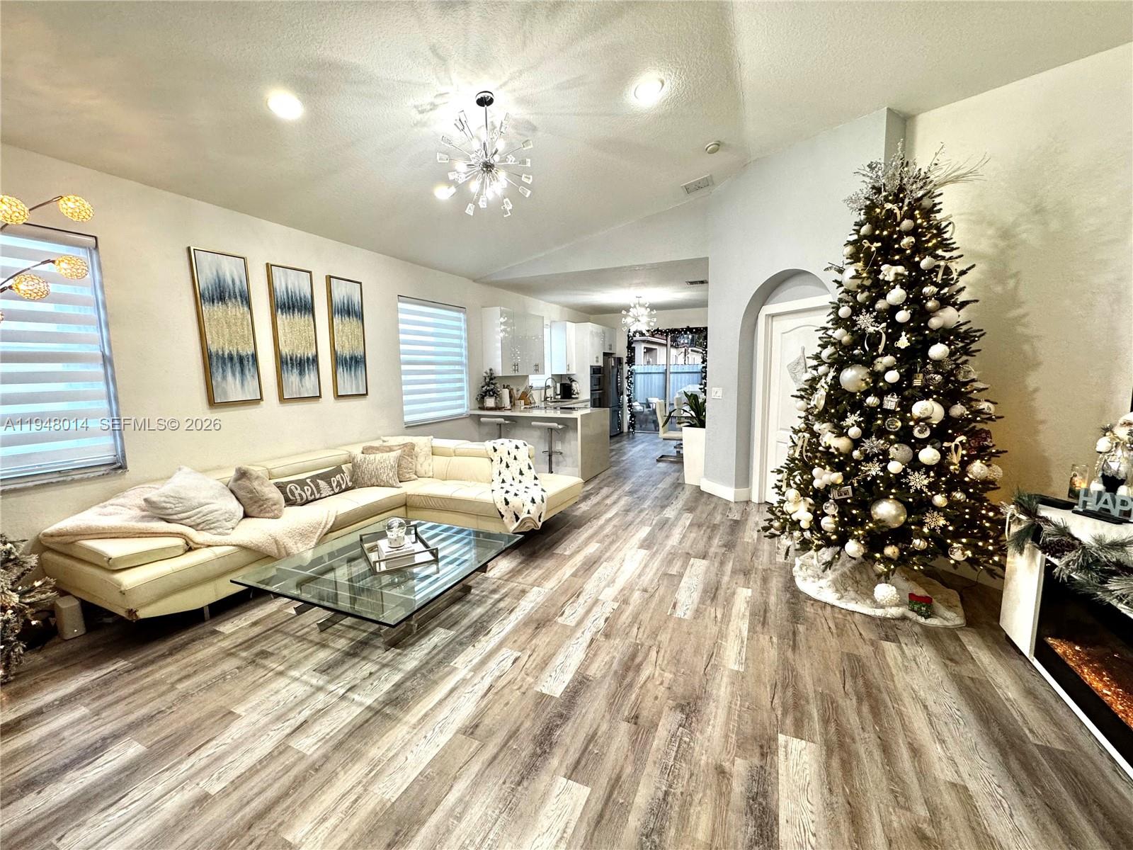 A living room features a sectional sofa, a glass coffee table, and a decorated Christmas tree — 2101 NE 37th Ter, Homestead FL 33033, HOMESTEAD, FL