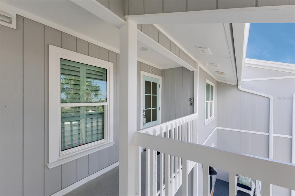 A gray exterior balcony features a light blue door, white railings, and a window — 6010 BOCA GRANDE CAUSEWAY UNIT C32, BOCA GRANDE, FL