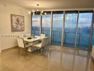 A dining area with a white table, four chairs, and floor-to-ceiling windows overlooking a city — 465 Brickell Ave # 5402, Miami FL 33131, MIAMI, FL