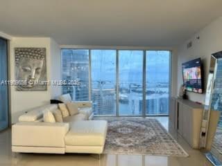 A living room features a white sectional sofa, a patterned area rug, and floor-to-ceiling windows — 465 Brickell Ave # 5402, Miami FL 33131, MIAMI, FL