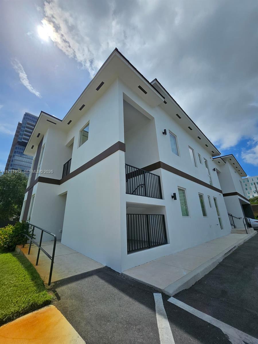 A two-story white building with dark brown trim and black metal railings — 210 SE 10th St, Hallandale Beach FL 33009, HALLANDALE BEACH, FL