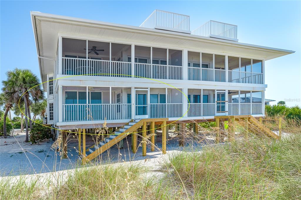 The exterior of a two-story beach house features a screened-in porch on the lower level — 7470 PALM ISLAND DRIVE UNIT 2811, PLACIDA, FL