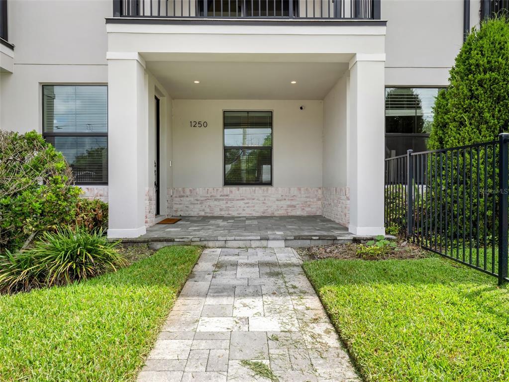 A paved walkway leads to the covered front porch of a two-story residential building — 1250 FORMOSA AVENUE, WINTER PARK, FL