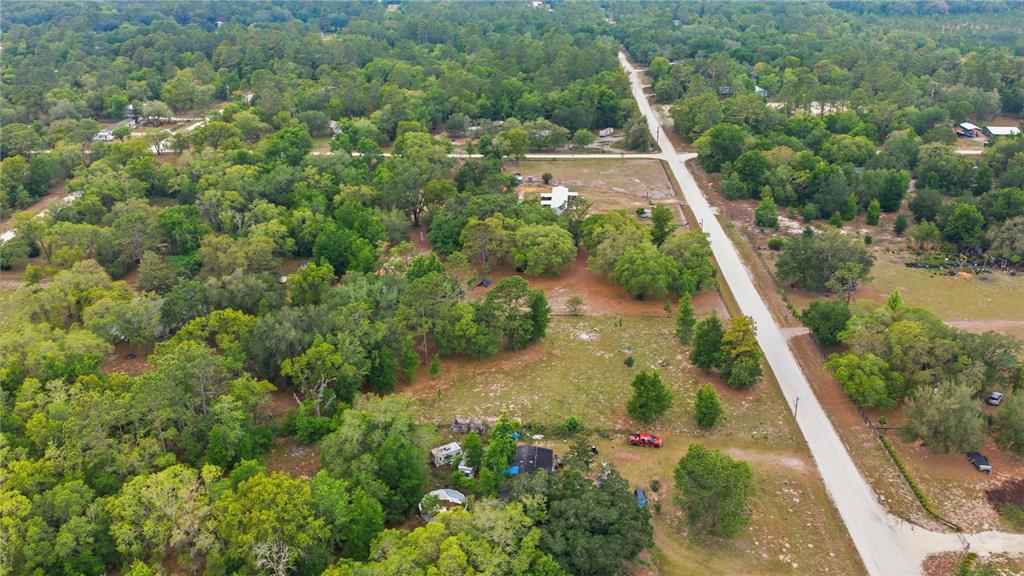 An aerial view shows a rural property with a house, outbuildings, and trees — TBD SE 66 STREET, MORRISTON, FL