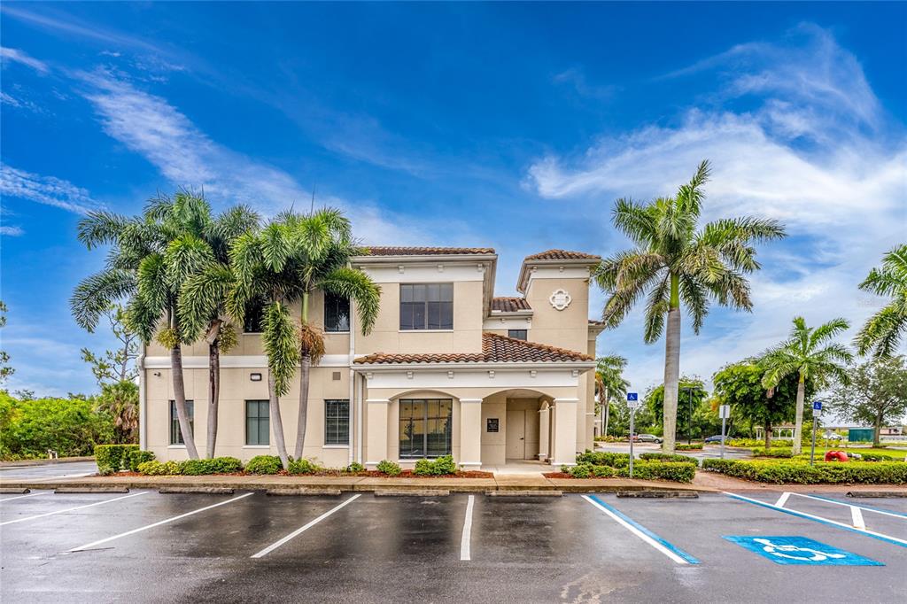 A two-story commercial building with a tiled roof and palm trees in a parking lot — 5900 PAN AMERICAN BOULEVARD, NORTH PORT, FL
