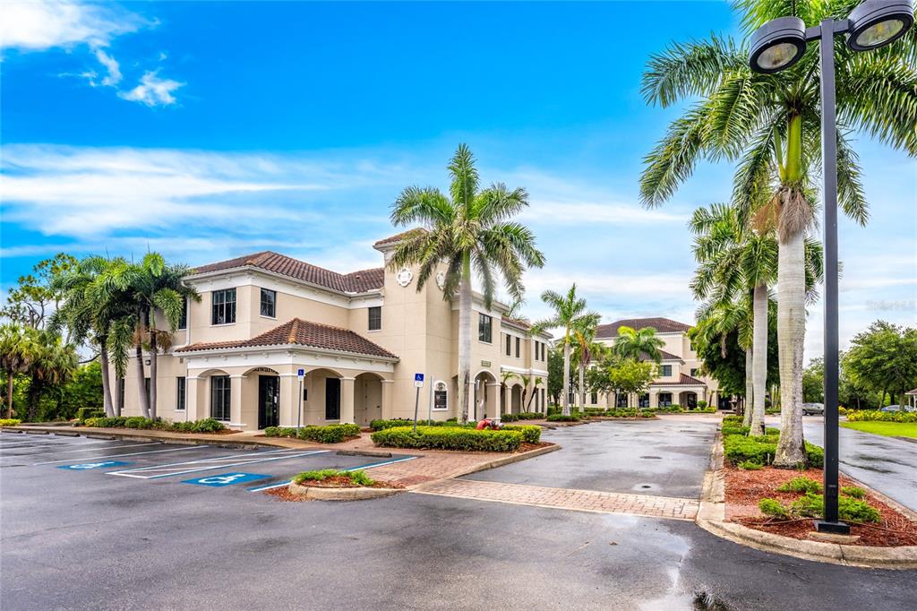 A two-story commercial building with a tile roof, palm trees, and a paved parking lot — 5900 PAN AMERICAN BOULEVARD, NORTH PORT, FL