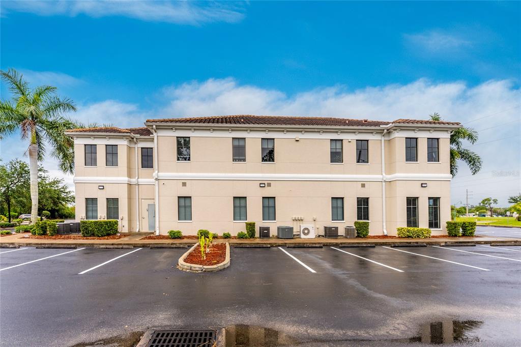 A two-story commercial building with a tan stucco exterior sits behind a paved parking lot — 5900 PAN AMERICAN BOULEVARD, NORTH PORT, FL