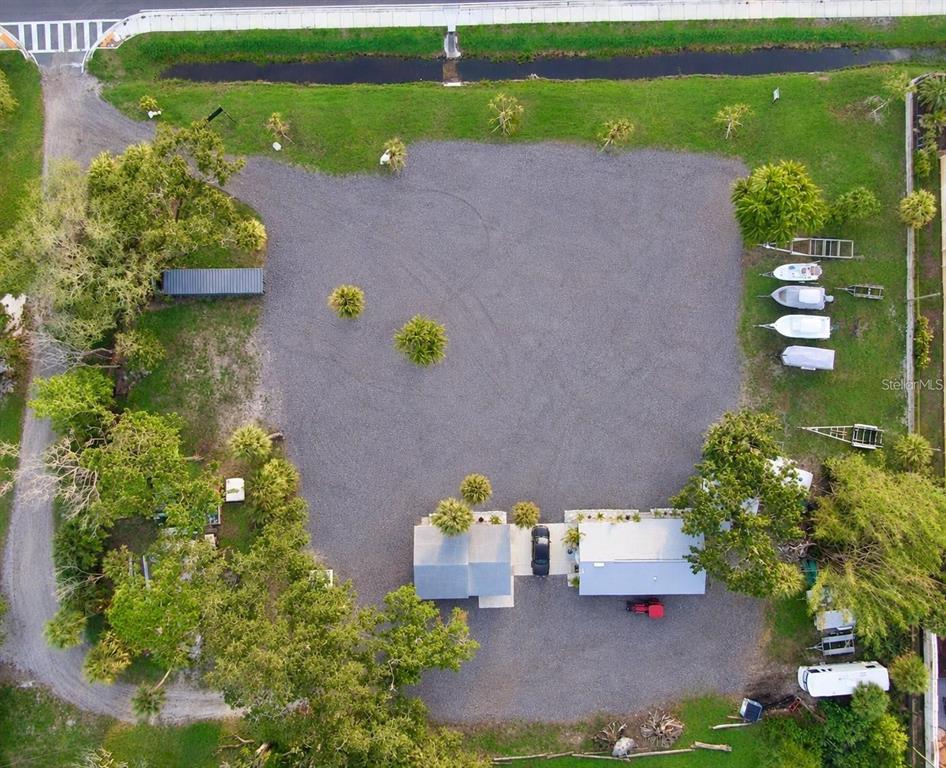 An aerial view shows a gravel lot with two small buildings and several parked boats — 1322 N PINELLAS AVENUE, TARPON SPRINGS, FL