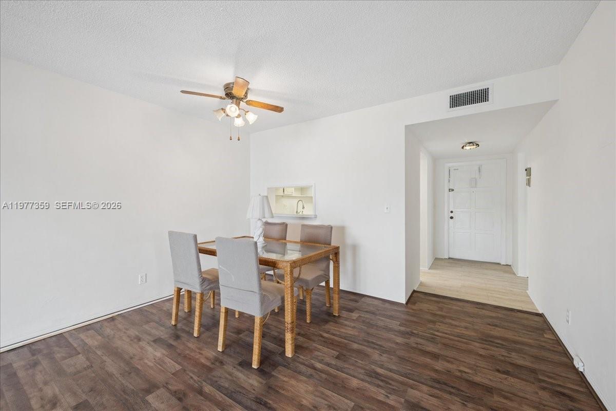 A dining area features a glass-topped table with four chairs and dark wood flooring — 1200 Hillcrest Ct # 315, Hollywood FL 33021, HOLLYWOOD, FL