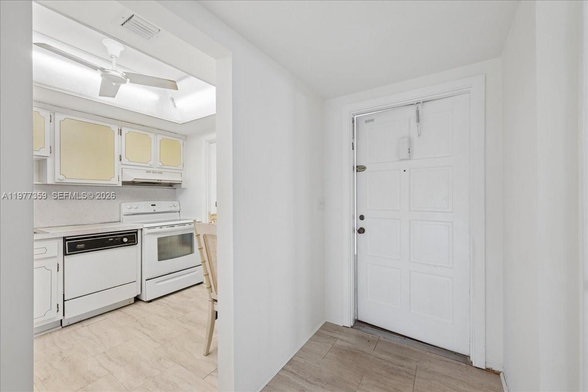 A white kitchen with a ceiling fan is visible through an opening next to an entryway — 1200 Hillcrest Ct # 315, Hollywood FL 33021, HOLLYWOOD, FL