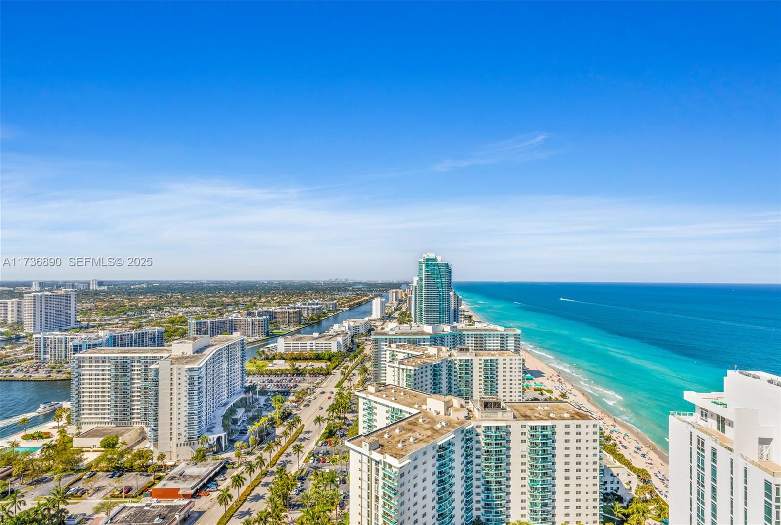 An aerial view shows high-rise buildings along a coastline with a beach and ocean — 4111 S Ocean Dr # 2904, Hollywood FL 33019, HOLLYWOOD, FL