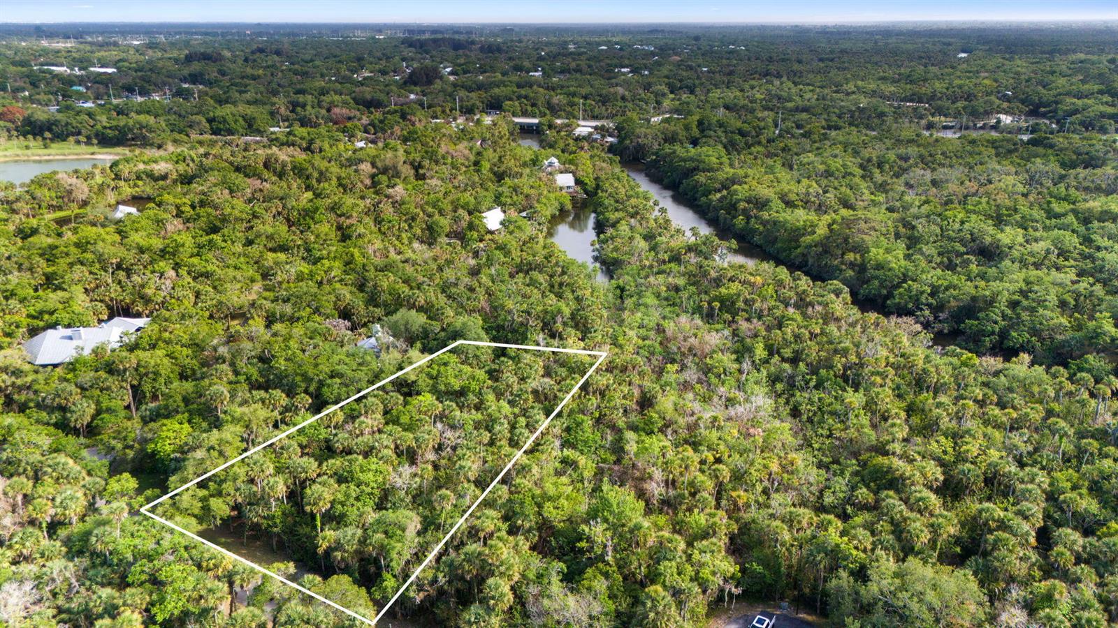 An aerial view shows a rectangular plot of land outlined in white amidst dense forest — Tbd Old River Road, Fort Pierce FL 34982, FORT PIERCE, FL