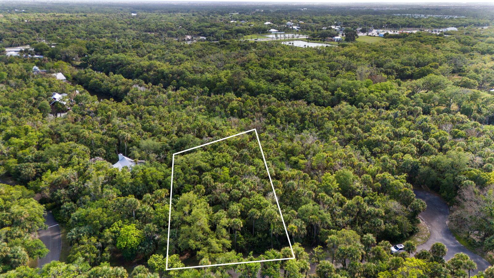 An aerial view shows a wooded, undeveloped rectangular lot outlined in white within a forest — Tbd Old River Road, Fort Pierce FL 34982, FORT PIERCE, FL