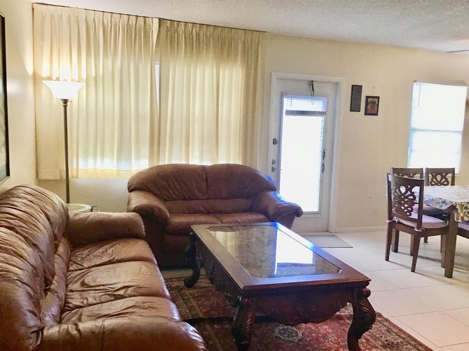 A living room features brown leather sofas, a glass-topped coffee table, and a dining area — 4004 Exeter A, Boca Raton FL 33434, BOCA RATON, FL