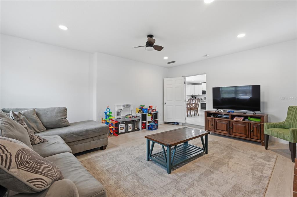 A living room features a grey sectional sofa, a wooden coffee table, and a television console — 1946 STRATHAVEN ROAD, WINTER PARK, FL