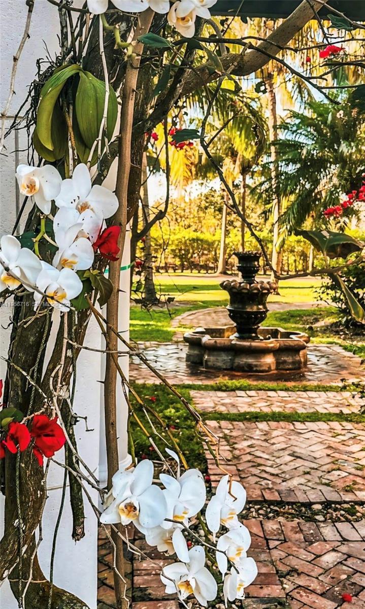 A stone fountain sits in a garden with a brick path and white orchids — 14949 SW 184th Ave, Miami FL 33196, MIAMI, FL