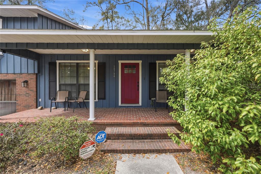 A blue house with a red front door and a brick porch — 18784 NW 230TH STREET, HIGH SPRINGS, FL