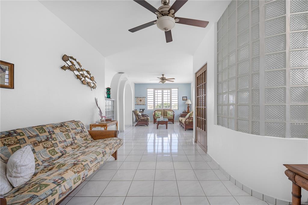 A long living room features white tiled floors, a glass block wall, and ceiling fans — SR 307 KM 7.0 VISTAMAR ST ESTANCIAS DE ALTA VISTA, BOQUERON, PR