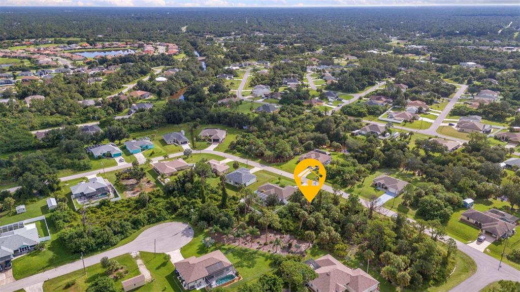 An aerial view shows a suburban neighborhood with houses surrounded by dense trees and vegetation — HIGHTOWER ROAD, NORTH PORT, FL