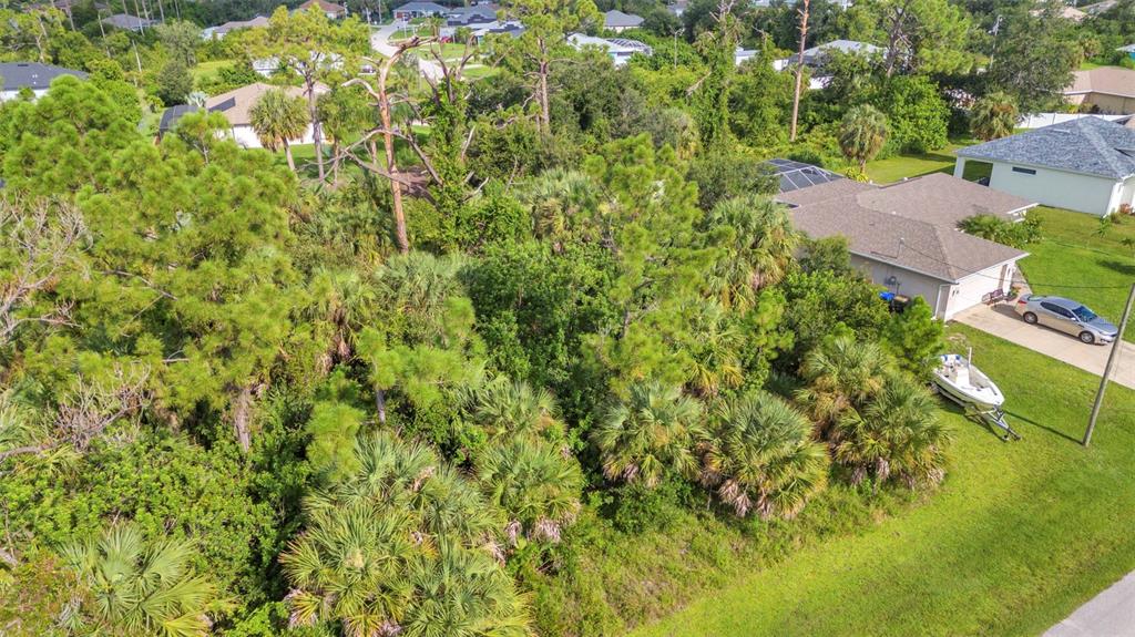 An aerial view shows a vacant, wooded lot situated between two residential houses — HIGHTOWER ROAD, NORTH PORT, FL