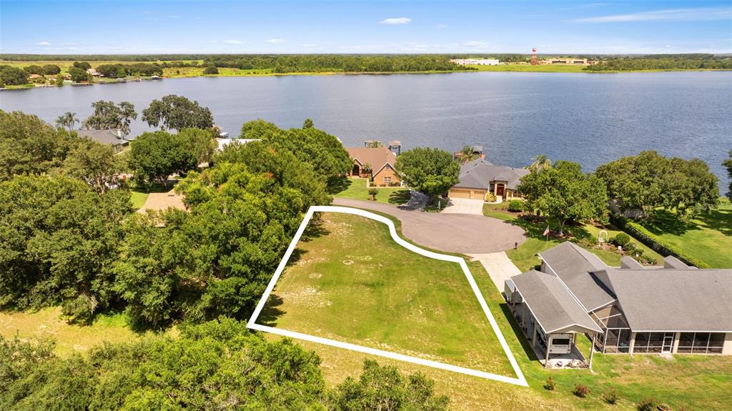 An aerial view shows a vacant residential lot outlined in white next to a house — 109 BAYBERRY DRIVE, POLK CITY, FL