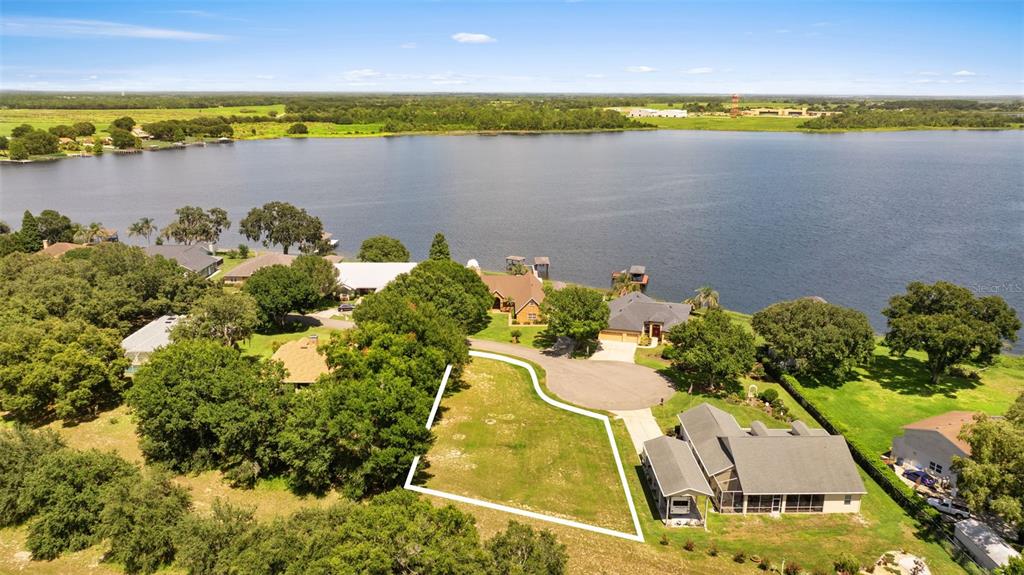 An aerial view shows a vacant residential lot outlined in white next to a house — 109 BAYBERRY DRIVE, POLK CITY, FL