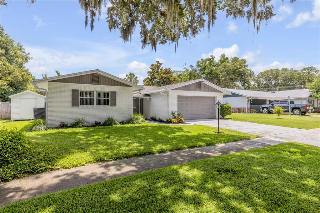 A single-story white brick house with a two-car garage and a front lawn — 3655 DAME STREET, PORT ORANGE, FL